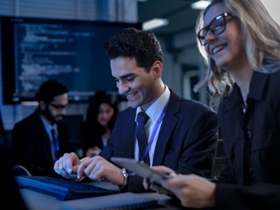 A developer points enthusiastically to the screen, showing his colleague the elegant and efficient code generated by their generative AI coding partner, celebrating a new level of productivity.